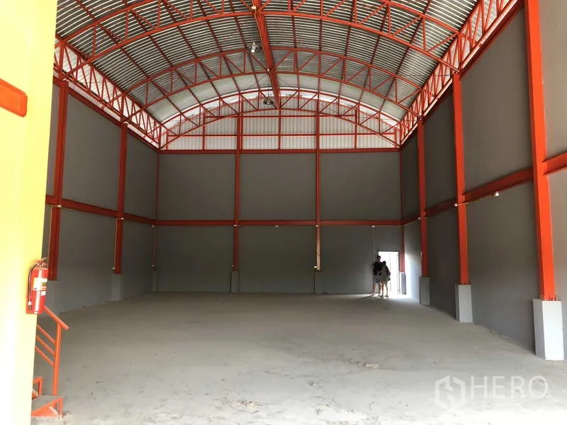 คลังสินค้า ให้เช่าในNonthaburi - ภายในโกดังโปร่ง เพดานโค้ง โครงเหล็กสีแดง และพื้นโล่งสำหรับจัดเก็บหรือผลิตเบา