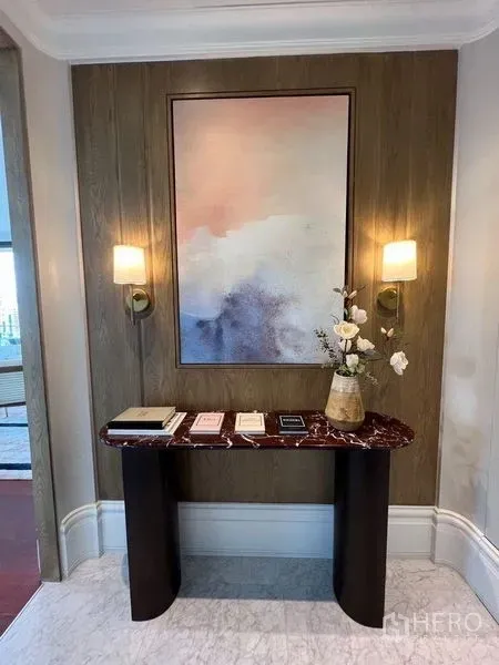 公寓 出租在Watthana, Bangkok - 入户玄关：木质墙面、壁灯、艺术画与石面玄关桌。