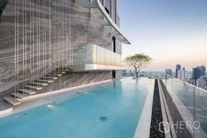 公寓 出租在Watthana, Bangkok - 屋顶无边泳池，玻璃护栏与城市天际线景观。