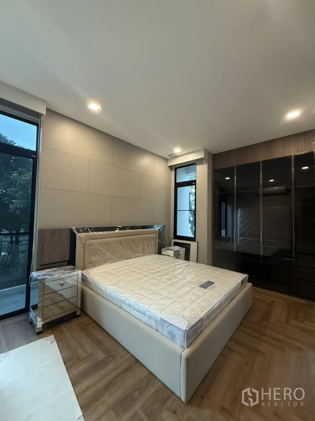 Detached House for rent in Saphan Sung, Bangkok - Bedroom with mirrored wardrobe doors and access to a balcony.