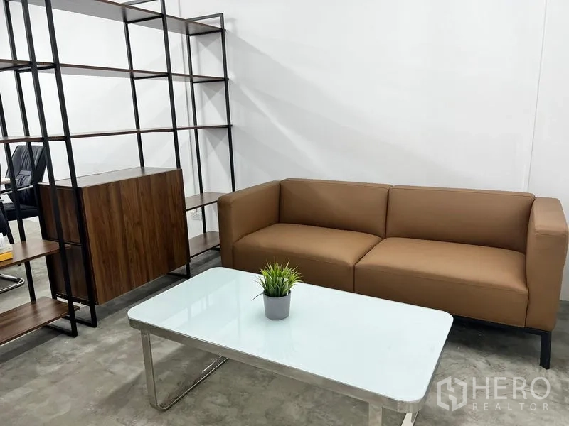 办公空间 出租在Sathon, Bangkok - 极简风休息区的棕色沙发与白色茶几特写。