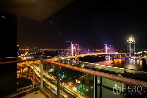 คอนโด ขาย - ระเบียงชั้นสูงชมสะพานและวิวริมแม่น้ำยามค่ำคืนที่สวยงาม