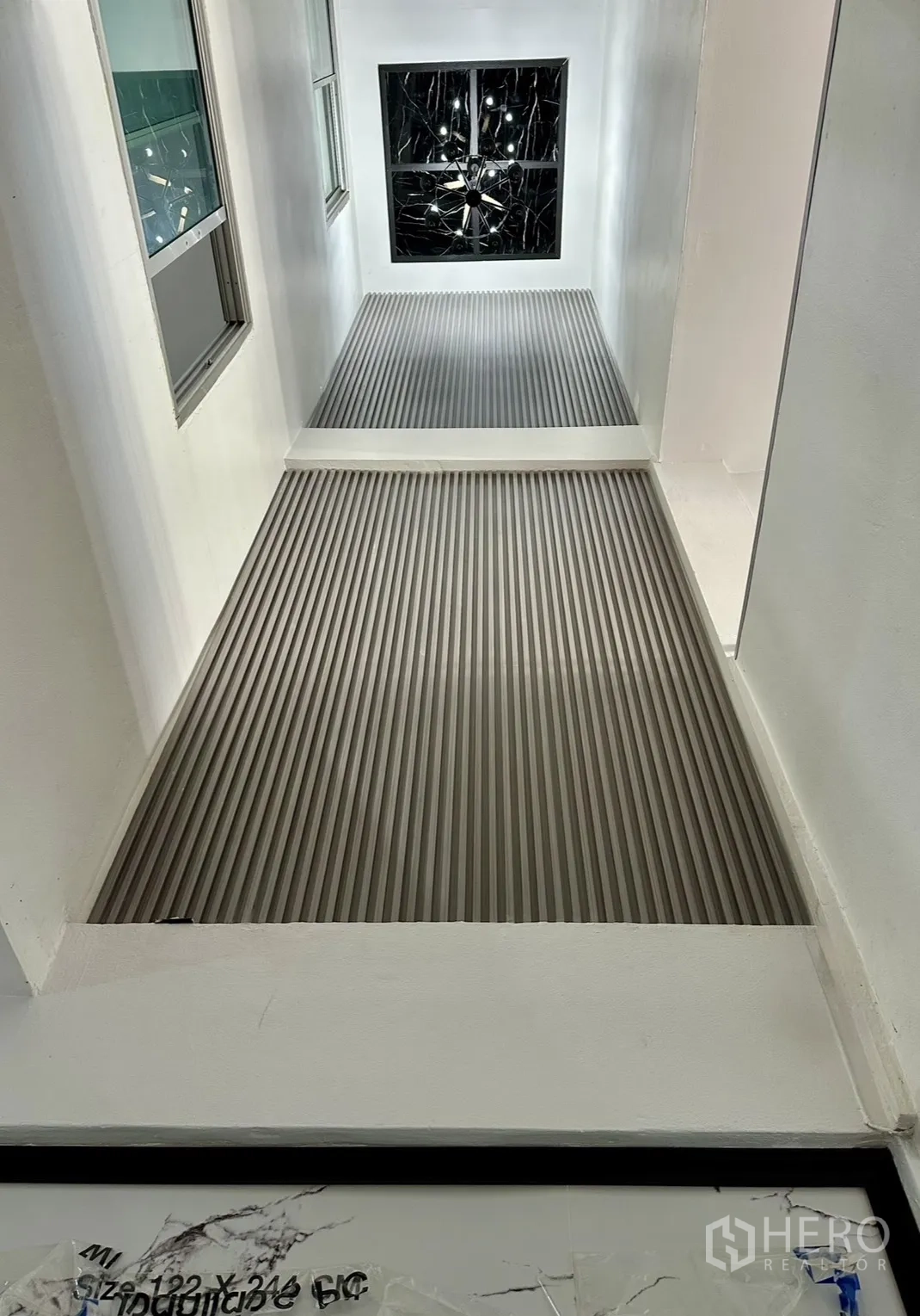 Home Office for rent in Khlong Toei, Bangkok - Bright atrium with a slatted metal walkway and ceiling light.