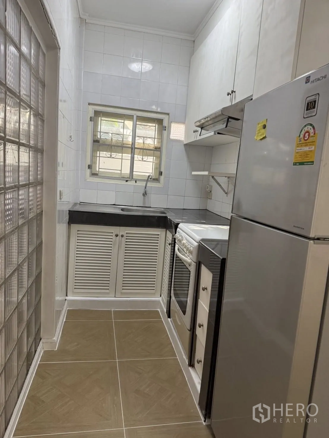 独栋房屋 for rent in Khlong Toei, Bangkok - 紧凑实用的厨房，配橱柜、炉灶烤箱、抽油烟机、冰箱与水槽。