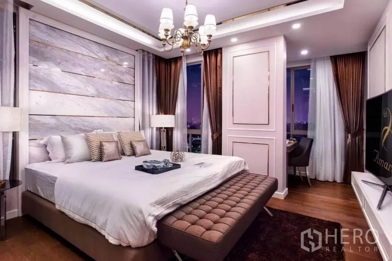 公寓 出租在Huai Khwang, Bangkok - 主卧配吊灯、转角窗、电视与软包脚凳。