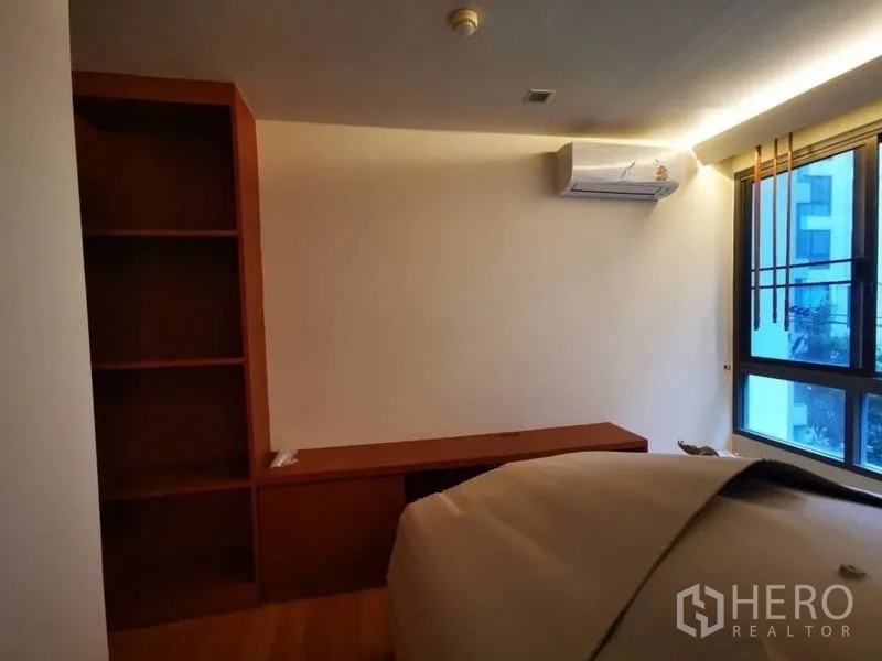 Condominium for sale in Khlong Toei, Bangkok - Second bedroom or study with built-in shelving, long desk and window.