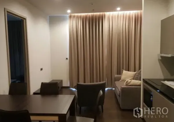 公寓 出租或出售在Watthana, Bangkok - 开放式客餐厅，紧凑厨房、筒灯与整面窗帘。