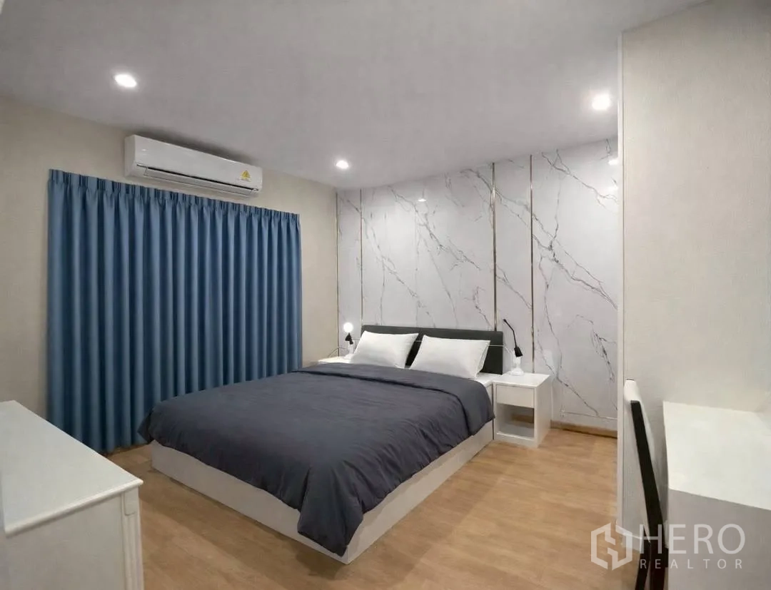 独栋房屋 for rent in Suan Luang, Bangkok - 温馨卧室，蓝色窗帘与大理石纹墙面，床头柜。