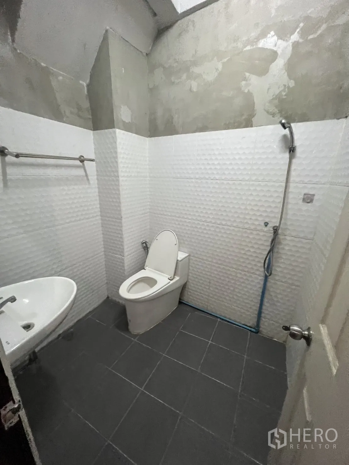 Shophouse for rent in Watthana, Bangkok - Bathroom with shower, white textured tiles and grey floor.