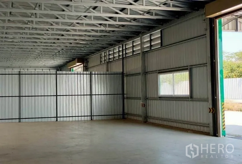 货栈 出租在Pak Kret, Nonthaburi - 仓库内部，钢桁架屋顶、混凝土地坪、侧窗与大开口。
