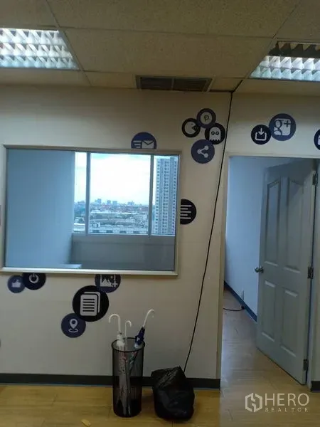 Office Space for rent - Office wall with glass internal window and tech-themed decals, door to separate room and city outlook.