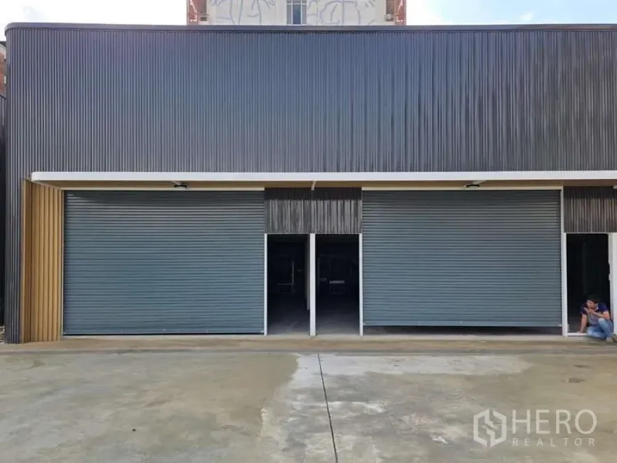Warehouse for rent in Wang Thonglang, Bangkok - Front elevation of a warehouse unit with two roller shutters and a covered loading apron.