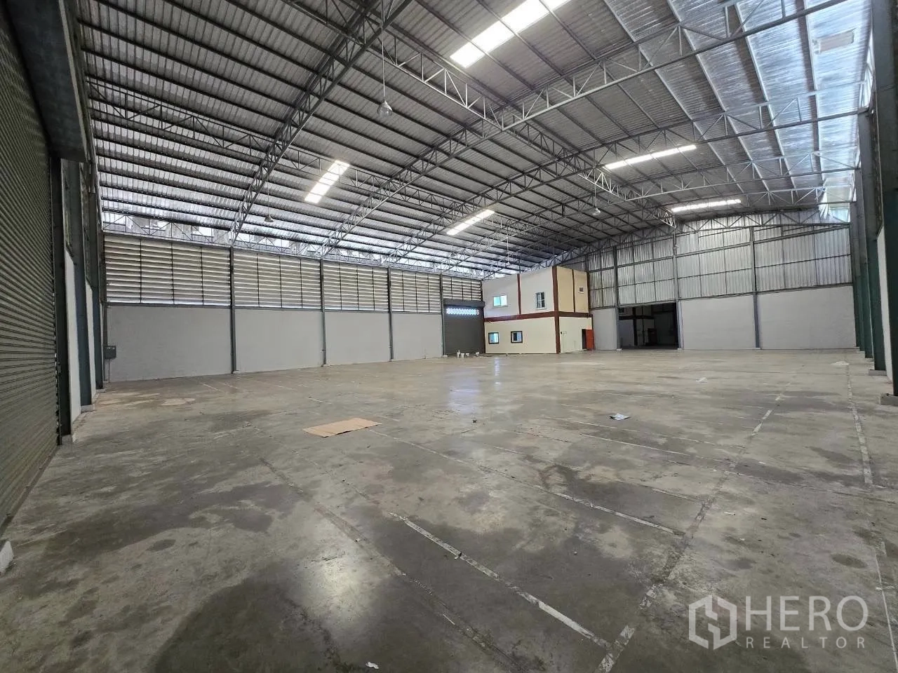 Warehouse for rent or sale in Mueang Samut Sakhon, Samut Sakhon - Wide open interior storage area with high ceiling and built-in office rooms.
