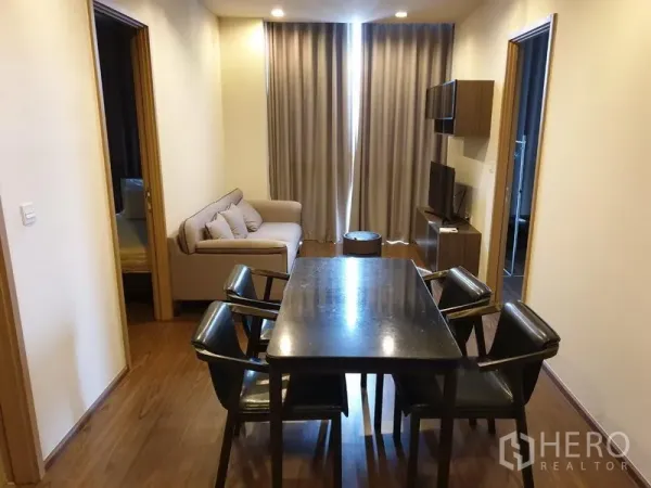 Condominium for rent in Watthana, Bangkok - Open-plan living and dining with a six-seat table, sofa, media console and full-length curtains in a modern Bangkok condo.