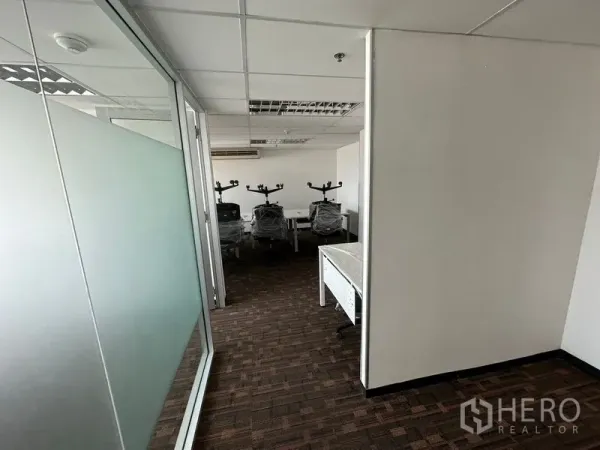 办公空间 出租在Watthana, Bangkok - 磨砂玻璃隔断的走廊，通往团队工作区。