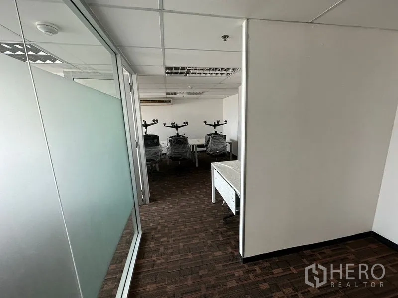 办公空间 出租在Watthana, Bangkok - 磨砂玻璃隔断的走廊，通往团队工作区。