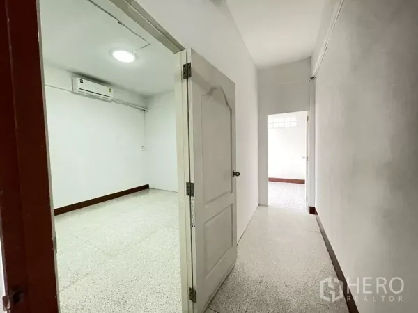 Home Office for rent in Din Daeng, Bangkok - Air-conditioned room opening to corridor with a white door and bright walls.