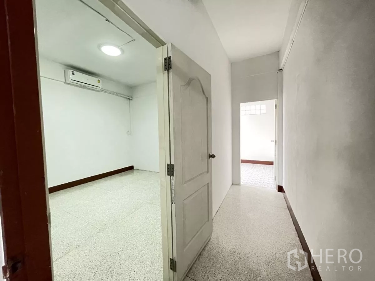 Home Office for rent in Din Daeng, Bangkok - Air-conditioned room opening to corridor with a white door and bright walls.