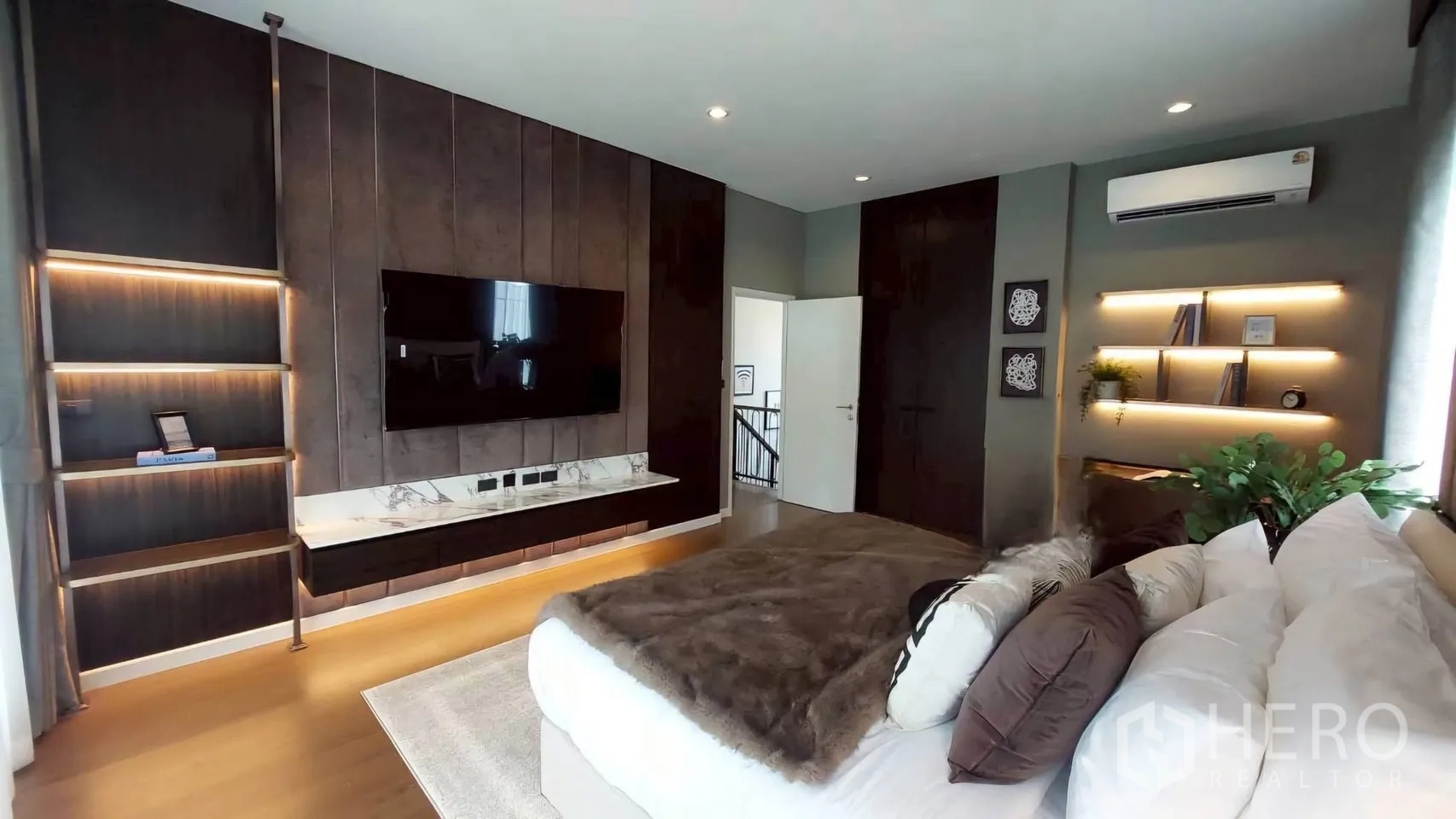 Detached House for rent in Bang Phli, Samut Prakan - Spacious bedroom with feature TV wall, shelving, and air conditioning.