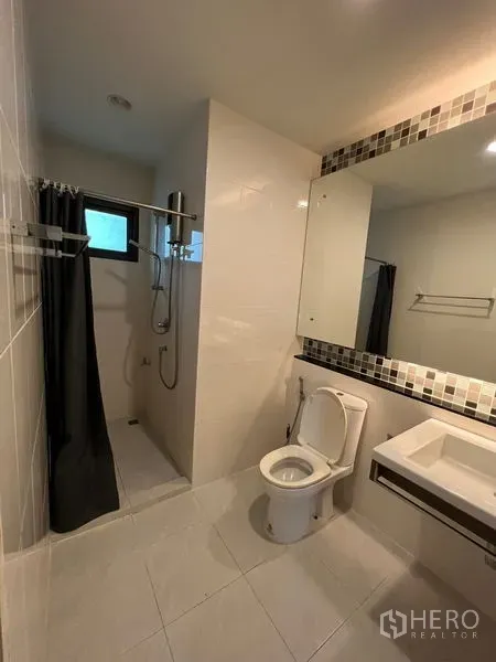 Detached House for rent or sale in Bang Kapi, Bangkok - Modern bathroom with walk-in shower, toilet and wide mirror.