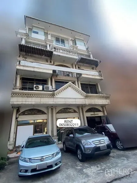 店屋 出租 - 多层临街商铺外观，古典立柱与拱形门面，带阳台与前方停车位，位于曼谷素坤逸纳娜区域。