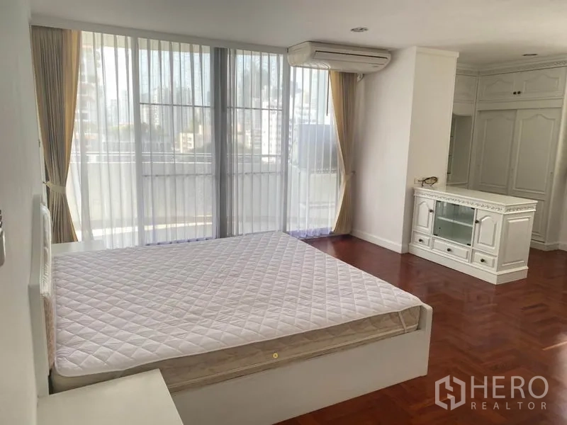 Condominium for rent in Watthana, Bangkok - Spacious master bedroom with floor-to-ceiling windows, parquet flooring and built-in cabinet.