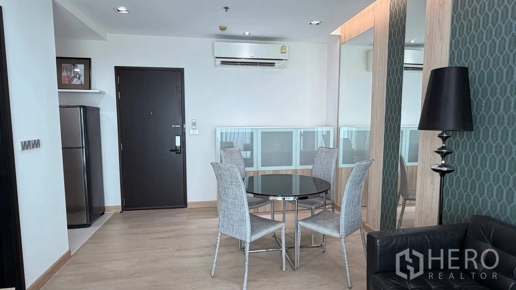 คอนโด for rent or sale in Watthana, Bangkok - พื้นที่รับประทานอาหารโต๊ะกลมกระจก 4 ที่นั่ง ข้างผนังกระจกเงา ใกล้ประตูทางเข้าและช่องวางตู้เย็น
