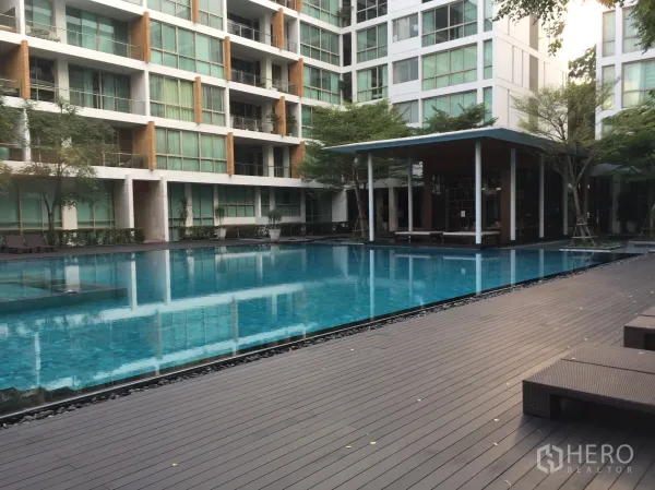 Condominium for rent in Khlong Toei, Bangkok - Resort-style condominium swimming pool with sun deck and modern low-rise buildings.