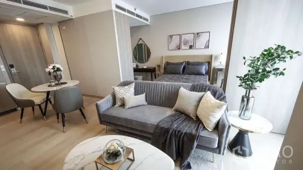Detached House for sale in Bang Lamung, Chon Buri - Contemporary bedroom and living area with grey sofa, dining set and light wood flooring.