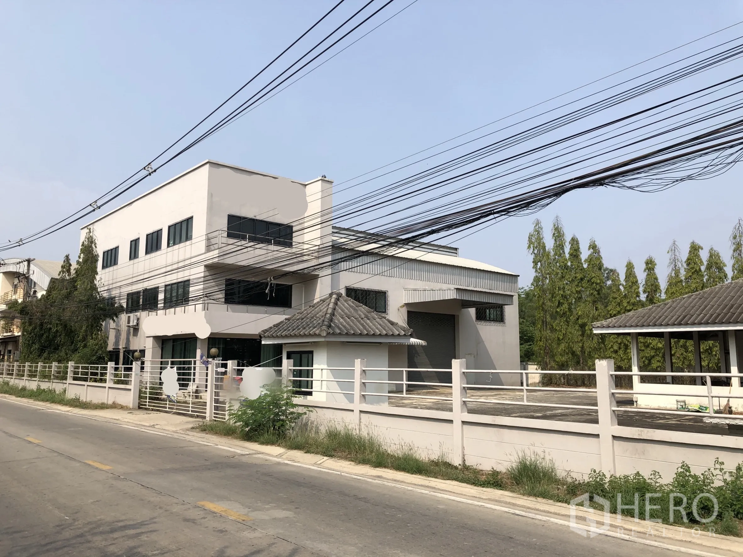 工厂 出售在Lam Luk Ka, Pathum Thani - 工厂正面外观，带办公楼、装卸区与围墙，临安静道路。