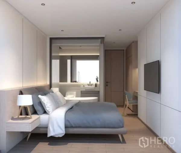 Condominium for rent or sale in Bang Rak, Bangkok - Master bedroom with built-in storage and a glass-partitioned ensuite featuring a vanity and soaking tub.