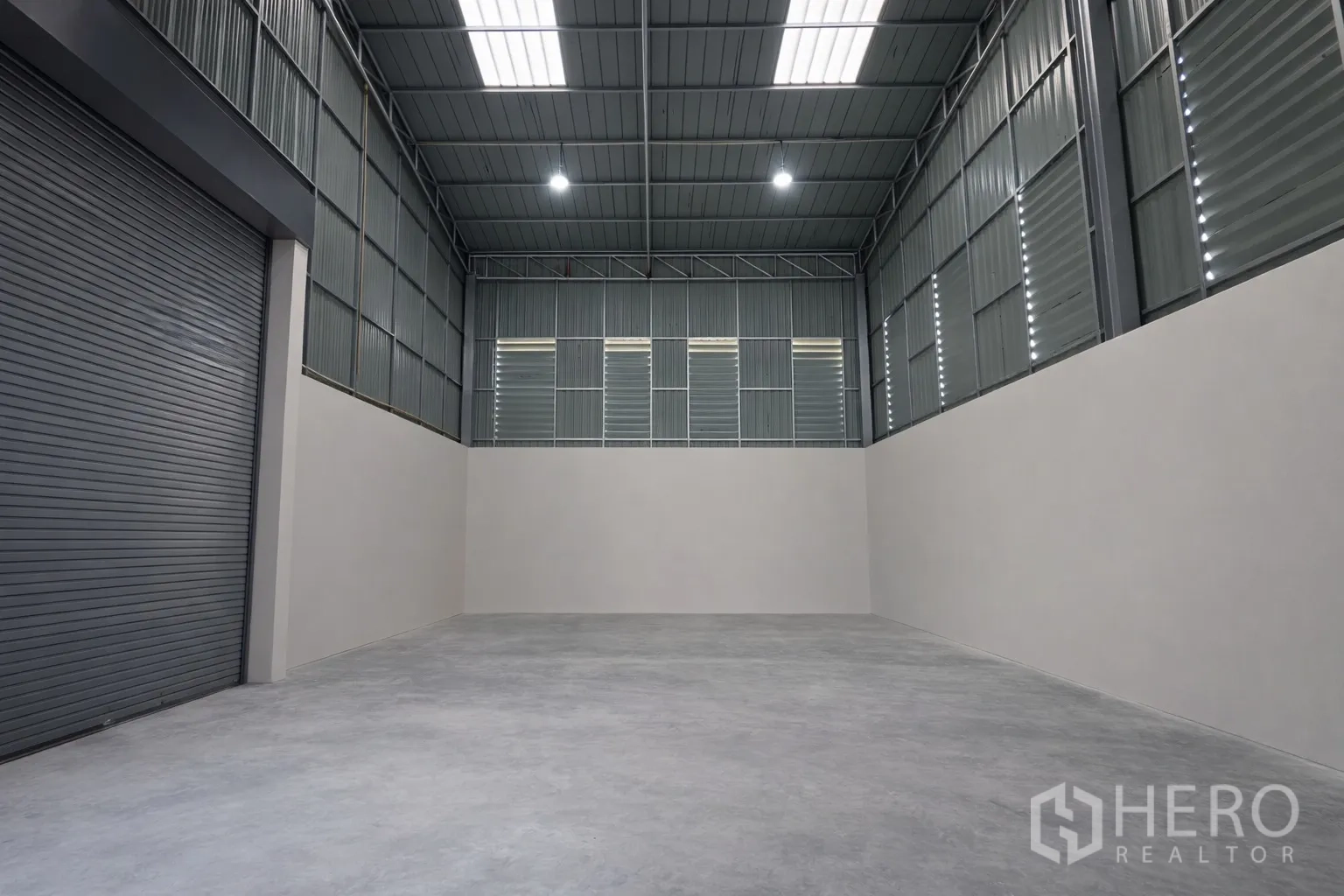 โกดัง for rent in Bang Kapi, Bangkok - โถงเก็บสินค้าหลังคาสูง พื้นคอนกรีต ผนังเมทัลชีท ช่องแสงบนหลังคา และประตูม้วนขนาดใหญ่