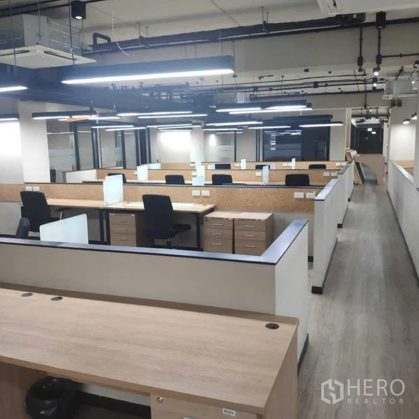 Office Space for rent - Work area with low-partition desks, drawer units and bright overhead lighting.