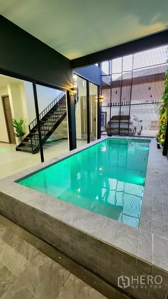 独立式住宅 出售在Khlong Toei, Bangkok - 抬高的瓷砖泳池，临车棚与竖向格栅遮挡。