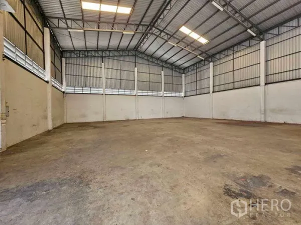 货栈 出租在Bang Bua Thong, Nonthaburi - 仓库内部高挑通透的钢结构屋顶与混凝土地面，采光良好。