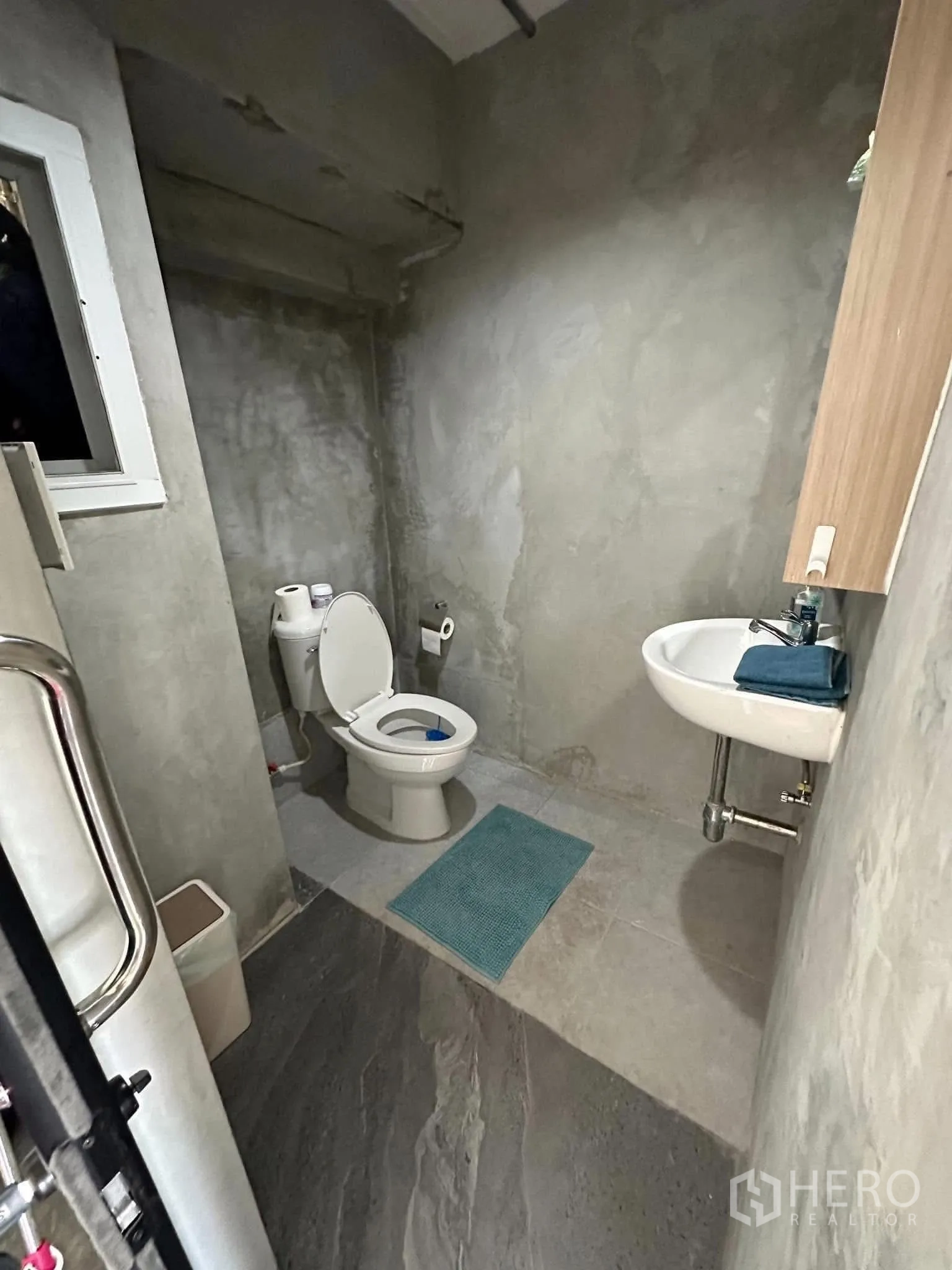 公寓 出租在Watthana, Bangkok - 客用卫浴，水泥风墙面，马桶与小洗手盆。