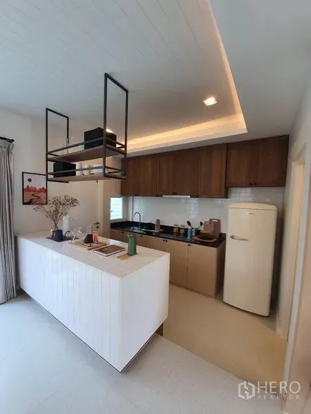 บ้าน ให้เช่าในPrawet, Bangkok - ครัวสมัยใหม่พร้อมไอส์แลนด์สีขาว ตู้ไม้ ชั้นแขวน และตู้เย็นสไตล์เรโทร