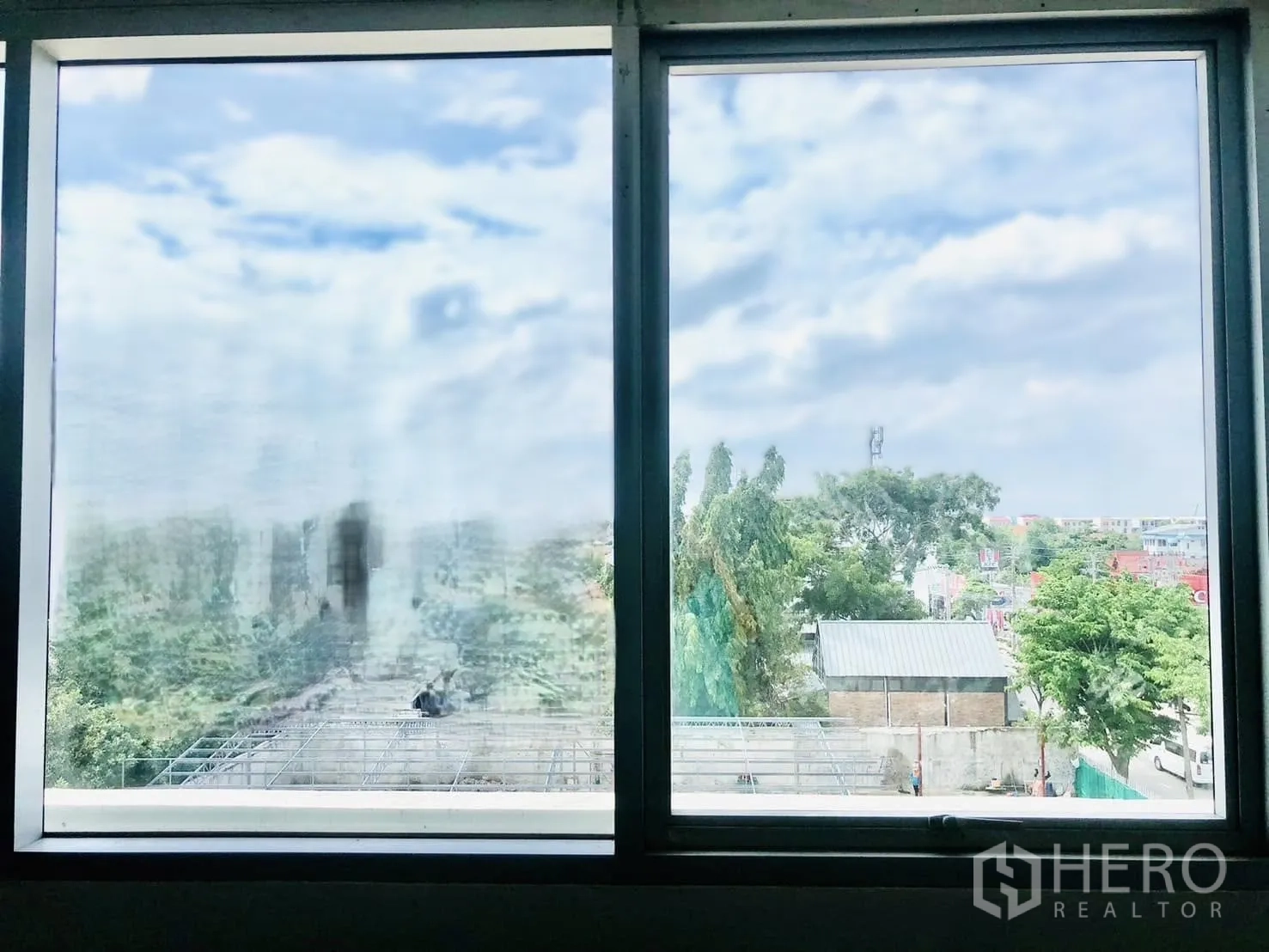 办公室 for rent in Lat Phrao, Bangkok - 双扇窗外可见蓝天、树木与低层建筑的景观。