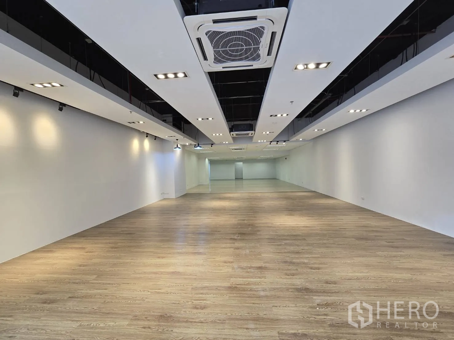 พื้นที่ขายของ for rent in Watthana, Bangkok - โถงโชว์รูมยาวพื้นลามิเนตลายไม้ พร้อมไฟดาวน์ไลท์
