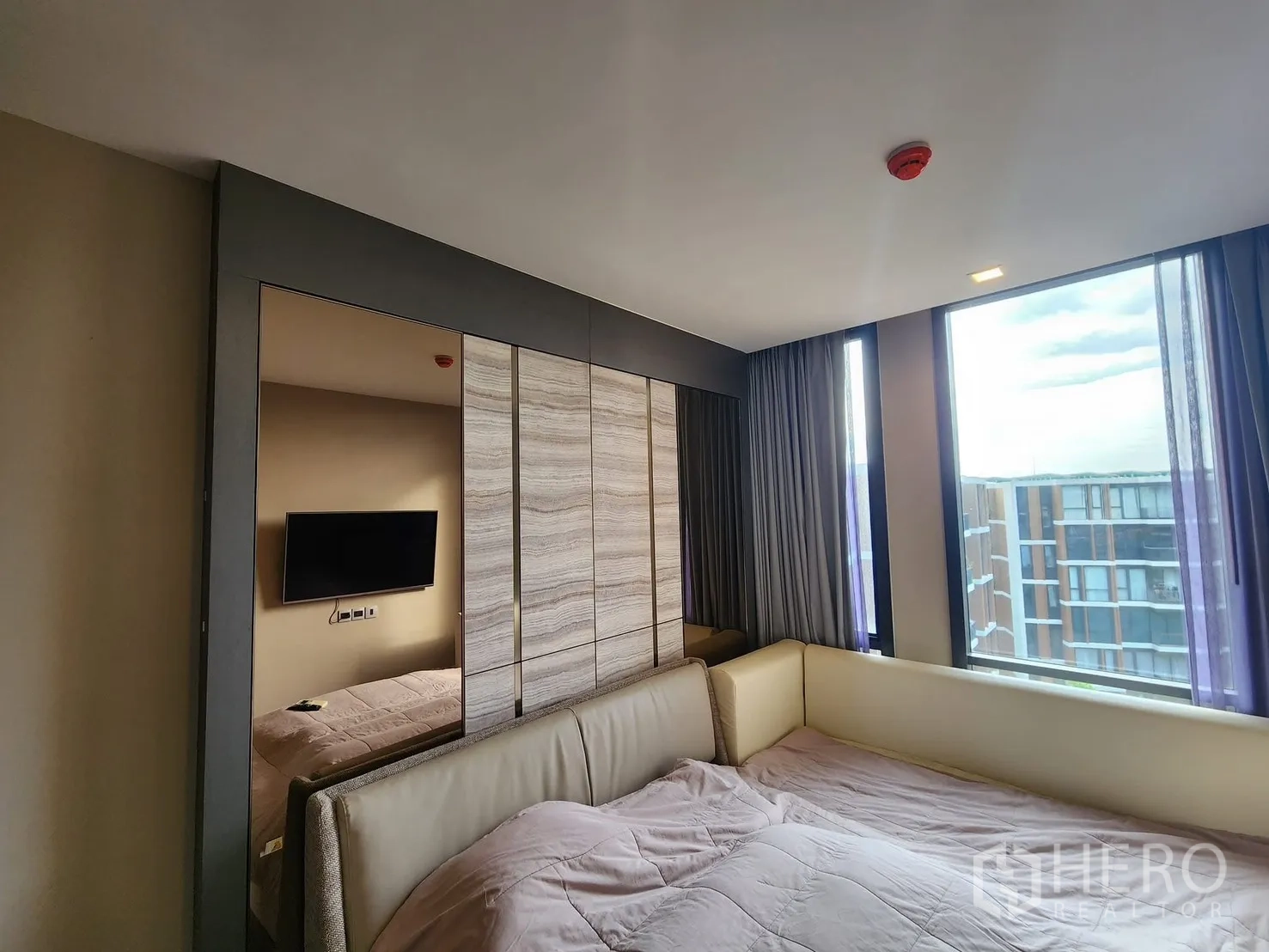 公寓 for rent in Watthana, Bangkok - 卧室设大窗与嵌入式衣柜，墙挂电视，可眺望中庭景观。