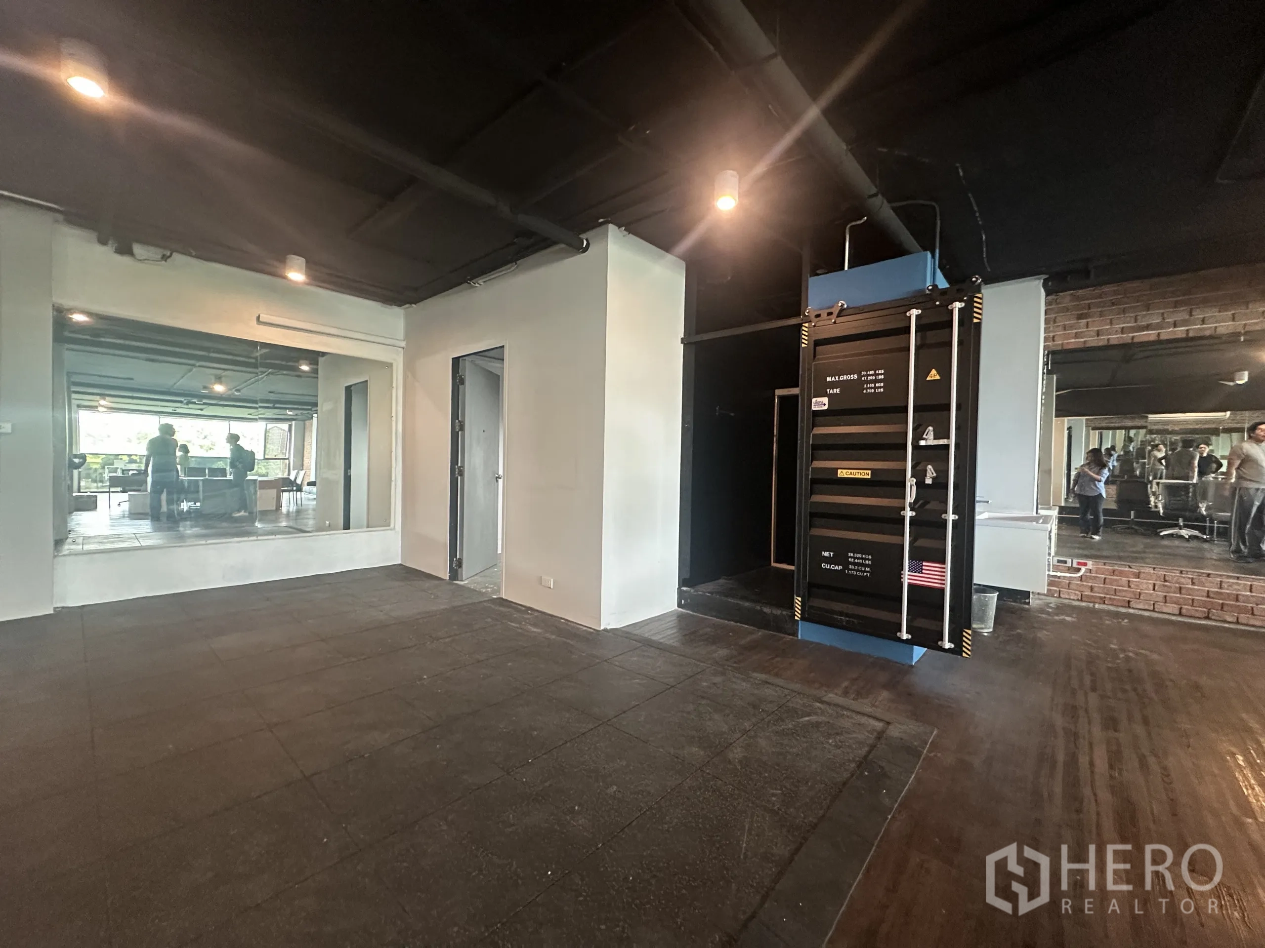 办公空间 出租在Watthana, Bangkok - 多功能区铺橡胶地砖，大镜面，旁有集装箱风服务器柜与私密房间。