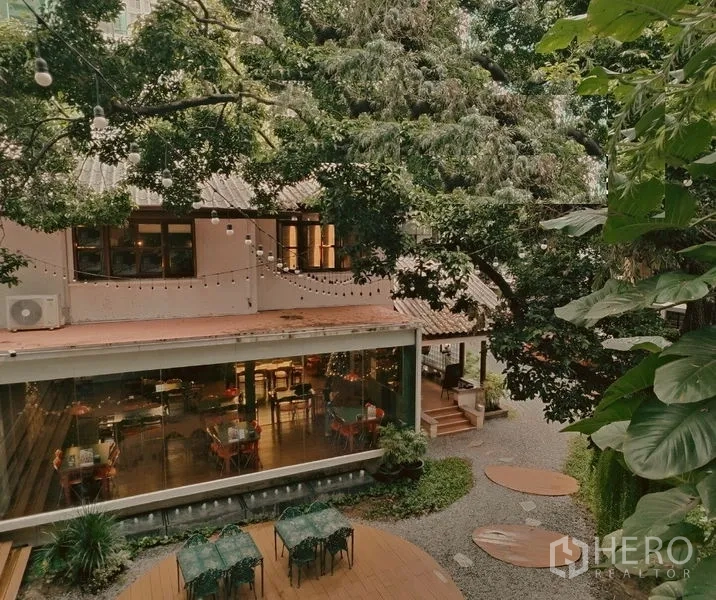Retail Space for rent in Pathum Wan, Bangkok - Glass-fronted dining hall opening to a leafy courtyard with string lights and seating.