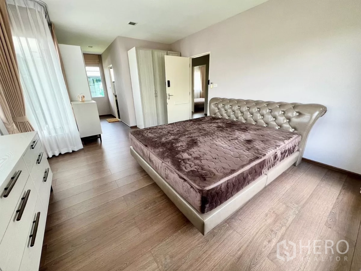 บ้าน ให้เช่าหรือขายในBang Phli, Samut Prakan - ห้องนอนใหญ่กว้าง เตียงหัวบุ พื้นไม้ และทางเข้าสู่วงจรห้องน้ำ-ตู้เสื้อผ้า.