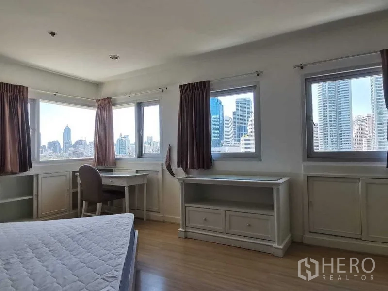 Condominium for rent in Khlong Toei, Bangkok - Corner bedroom with multiple windows, built‑in desks and skyline outlooks.