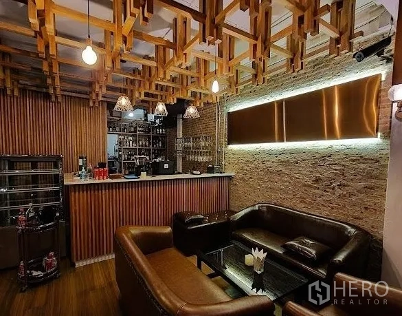 Retail Space for rent - Cozy lounge with leather sofas, wooden lattice ceiling, exposed brick wall and compact bar counter.