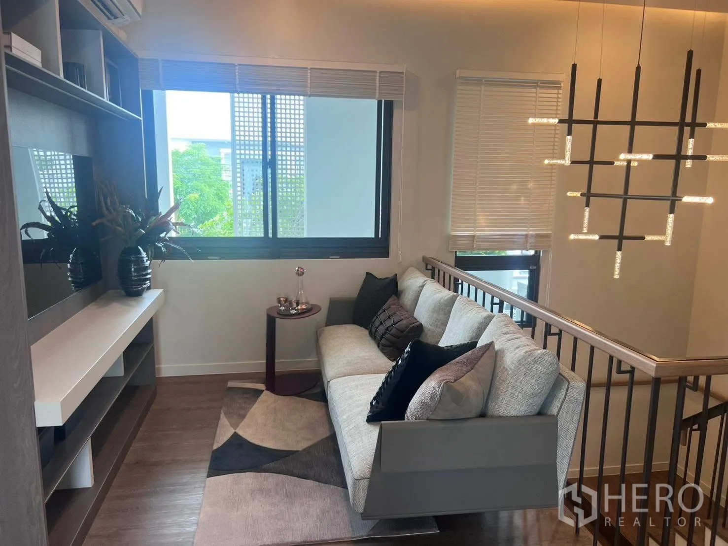 Detached House for rent or sale in Bang Phli, Samut Prakan - Upstairs family lounge with sofa, shelving, and large windows.