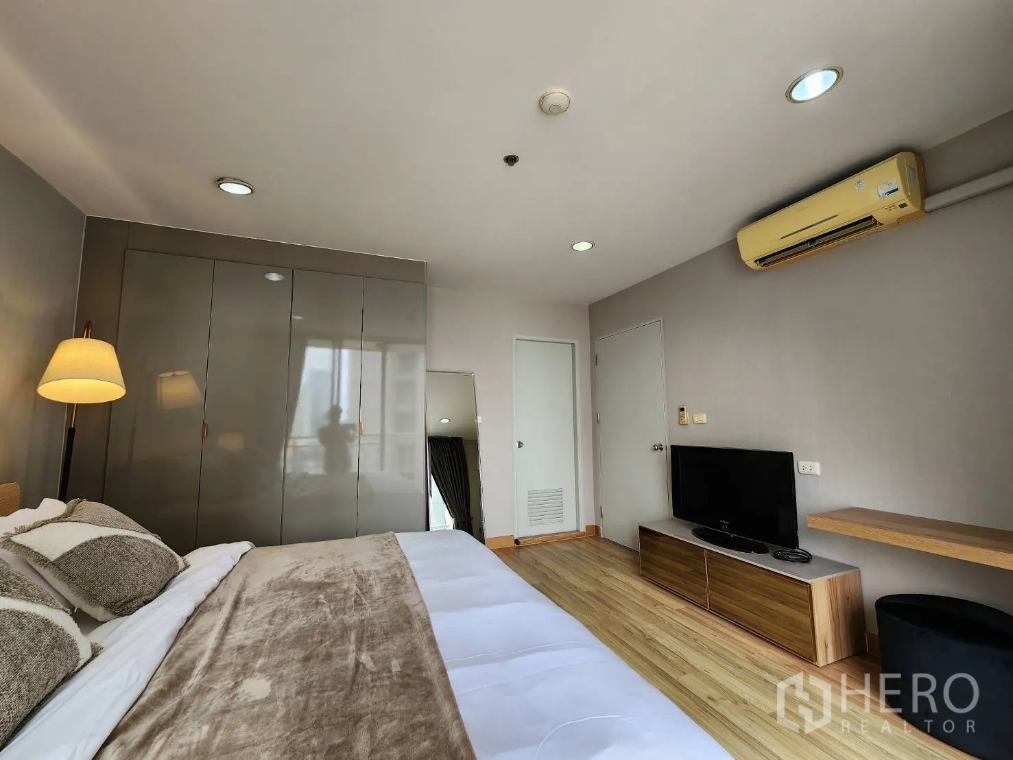 公寓 for rent in Watthana, Bangkok - 卧室内有电视柜、空调与高柜，木地板铺设。