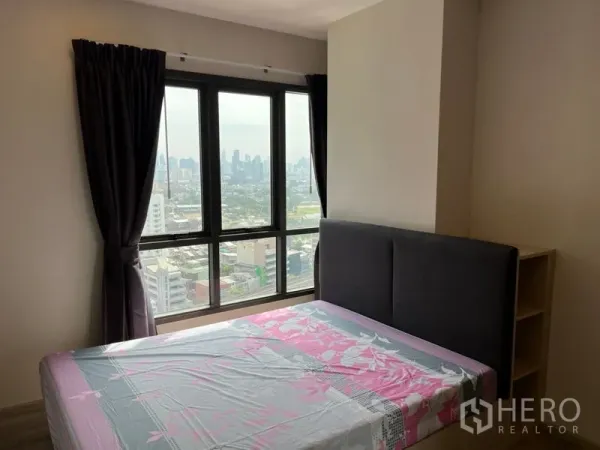 Condominium for sale in Phaya Thai, Bangkok - Bedroom with floor-to-ceiling windows and panoramic Bangkok skyline view.