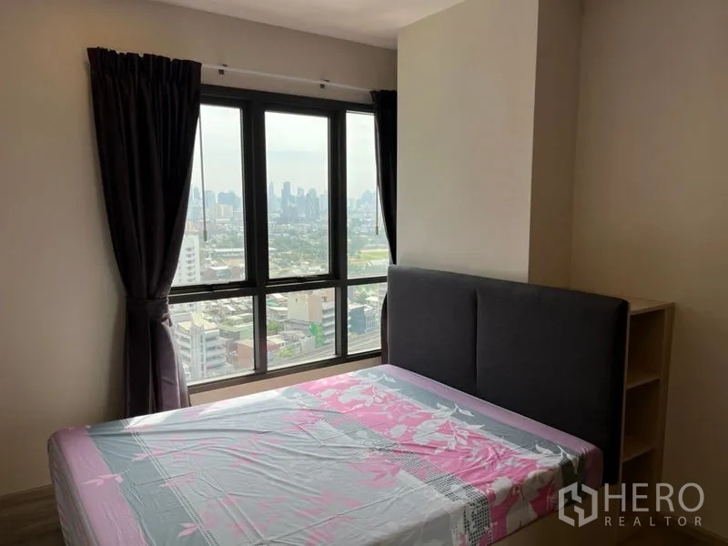 Condominium for sale in Phaya Thai, Bangkok - Bedroom with floor-to-ceiling windows and panoramic Bangkok skyline view.