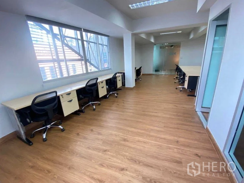 办公空间 出租在Khlong Toei, Bangkok - 走廊式工位带大窗，临玻璃入户门，动线通透。
